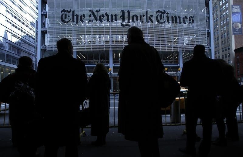 People line up for taxi across the street from the New York Times head office in New York, February 7, 2013. The New York Times Co, on Thursday, reported higher quarterly revenue as more people paid for its digital newspapers, and its shares jumped 11 percent. REUTERS/Carlo Allegri (UNITED STATES - Tags: BUSINESS MEDIA) - GM1E92803BH01