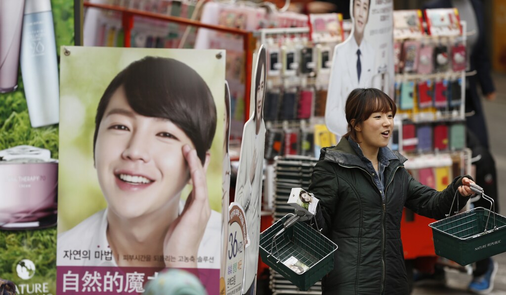 An employee of a cosmetic store promotes products at a shopping district in central Seoul April 8, 2013. Tension has been rising since the United Nations imposed new sanctions against North Korea in response to its third test of a nuclear weapon in February. Pyongyang has been further angered by weeks of joint military exercises by South Korean and U.S. forces and threatened both countries with nuclear attack. REUTERS/Lee Jae-Won (SOUTH KOREA - Tags: POLITICS BUSINESS SOCIETY) - GM1E9481LOY01