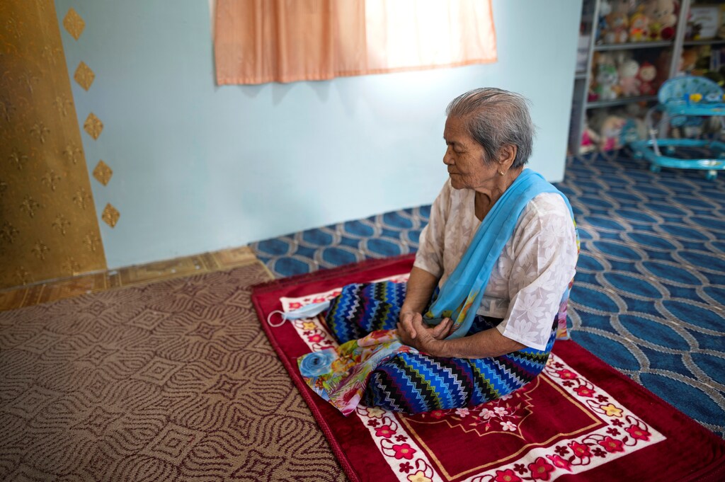 Daw Thein Khin, a 100-year-old woman survivor of the coronavirus disease (COVID-19) prays at her home