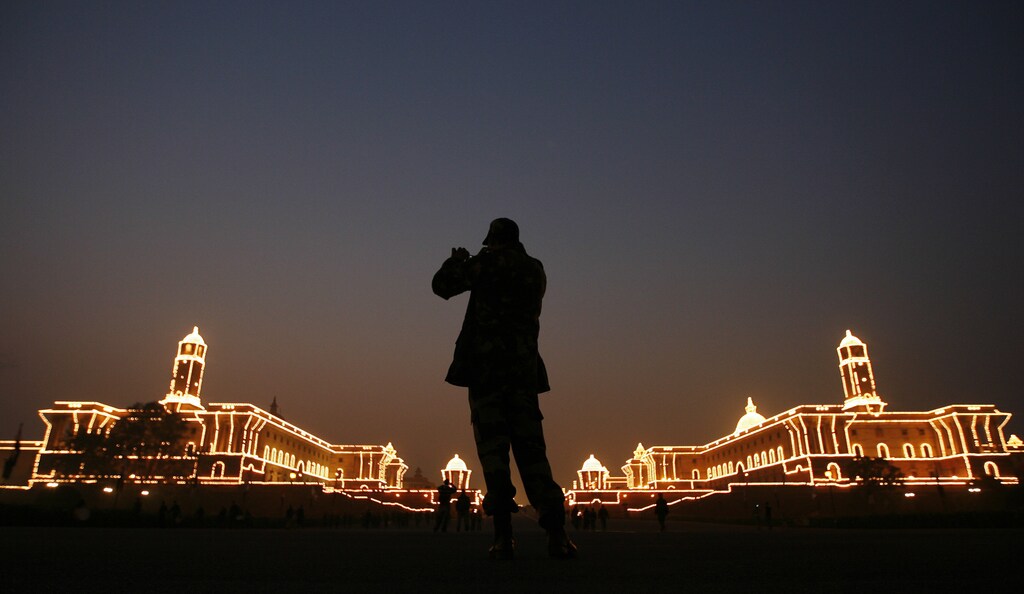An Indian soldier takes pictures of illuminated Indian Defence Ministry (L) and Home Ministry buildings during a rehearsal for the "Beating the Retreat" ceremony in New Delhi January 24, 2010. The ceremony, held every year on January 29, marks the official end of the Indian Republic Day celebrations. REUTERS/Adnan Abidi (INDIA - Tags: MILITARY CITYSCAPE SOCIETY ANNIVERSARY IMAGES OF THE DAY) - GM1E61O1NKN01