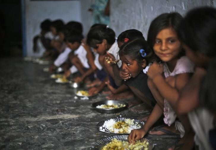 School children eat their free mid-day meal, distributed by a government-run primary school, at Brahimpur village in Chapra district of the eastern Indian state of Bihar July 19, 2013. Police suspect that India's worst outbreak of mass food poisoning in years was caused by cooking oil that had been kept in a container previously used to store pesticide, the magistrate overseeing the investigation said on Friday. REUTERS/Adnan Abidi (INDIA - Tags: DISASTER HEALTH FOOD EDUCATION TPX IMAGES OF THE DAY)
