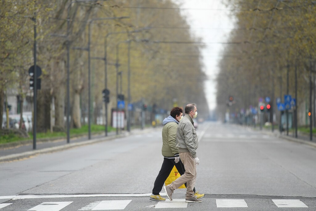 People walk in an empty street, during a lockdown against the spread of coronavirus disease (COVID-19) in Milan, Italy March 22, 2020. REUTERS/Daniele Mascolo - RC2ZOF9RNG6L