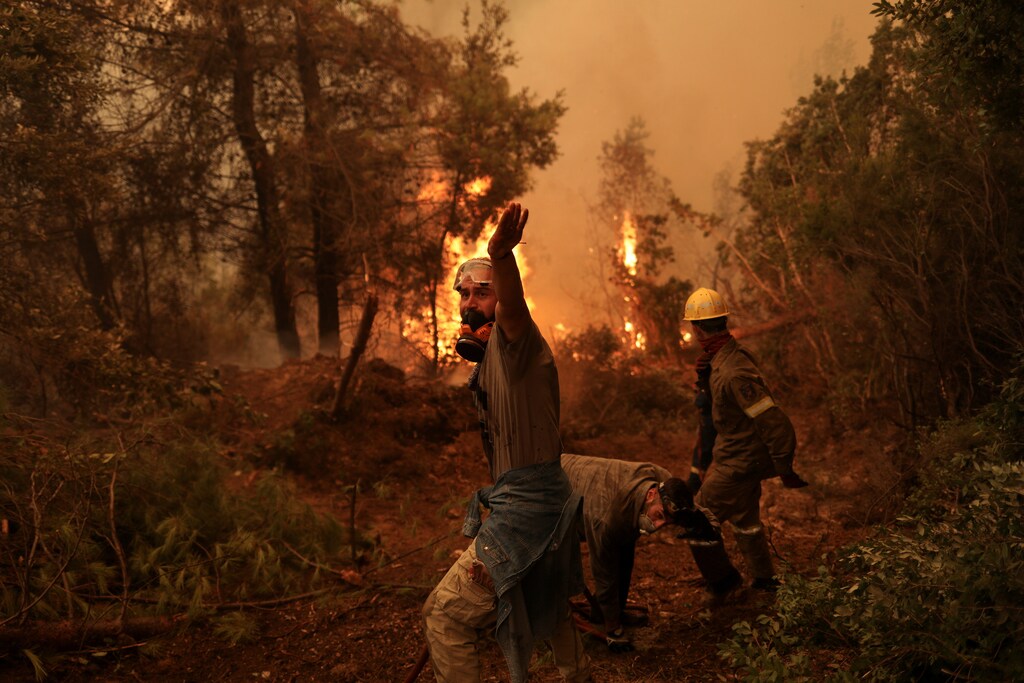 A volunteer reacts as a wildfire burns in the village of Galatsona, on the island of Evia, Greece, August 9, 2021. REUTERS/Stelios Misinas TPX IMAGES OF THE DAY - RC2Q1P9HJGE6