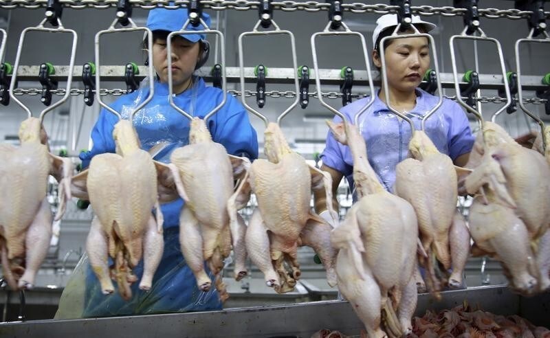 Employees work at a production line of a chicken processing factory in Shenyang, Liaoning province, August 9, 2014. China posted mild consumer inflation on Saturday, well below the annual target in July, giving authorities room to further relax monetary policy, but deflationary pressure for producers remained stubborn, highlighting a wobbly economic rebound. REUTERS/Stringer (CHINA - Tags: BUSINESS AGRICULTURE) CHINA OUT. NO COMMERCIAL OR EDITORIAL SALES IN CHINA - GM1EA89194901