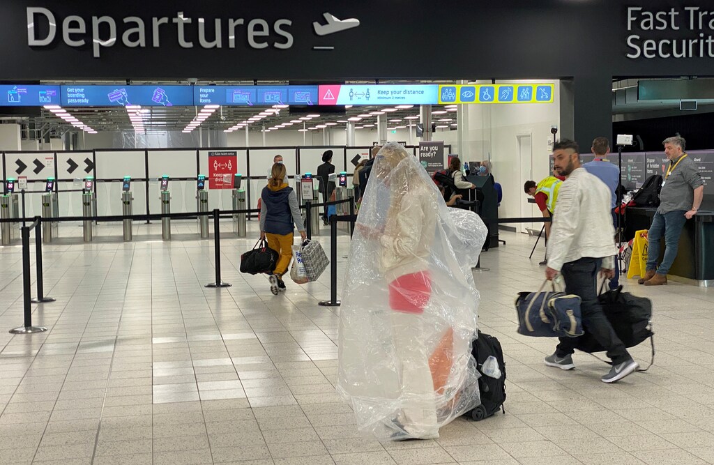 A passenger covered with a plastic bag is seen at Luton Airport, following the outbreak of the coronavirus disease (COVID-19), Luton, Britain, June 4, 2020. REUTERS/Paul Childs TPX IMAGES OF THE DAY - RC2B2H93QR0M