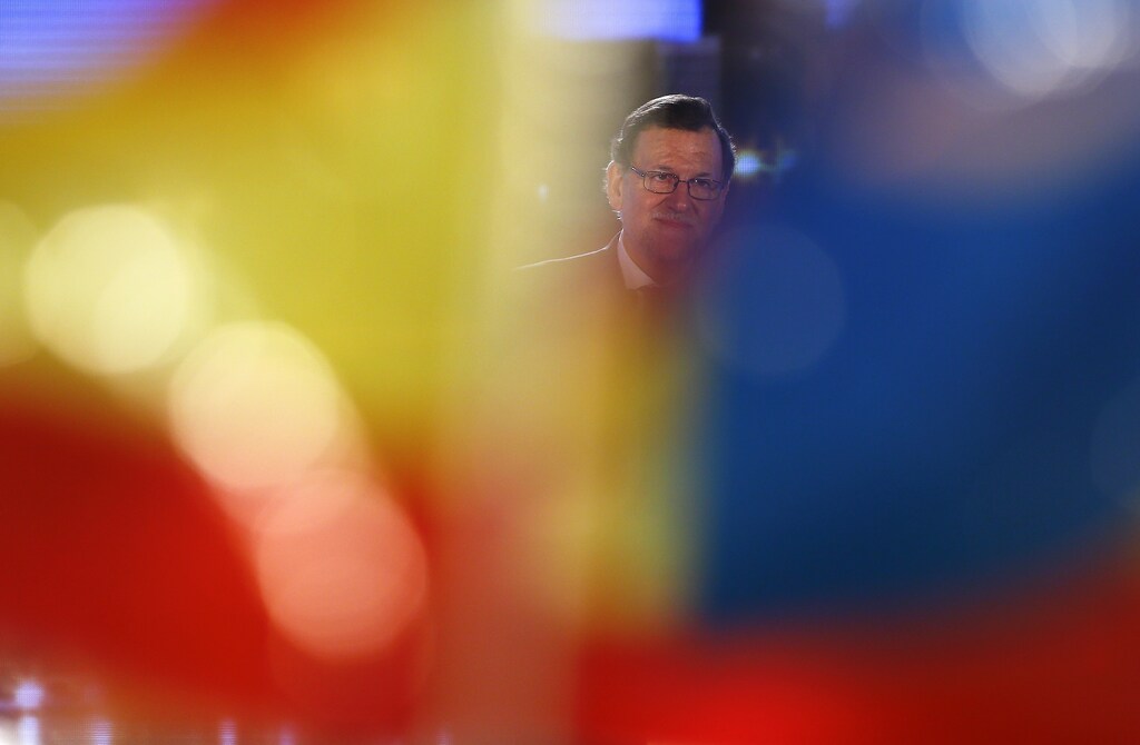 Spanish Prime Minister and People's Party (PP) leader Mariano Rajoy is seen between flags during a campaign rally ahead of Spain's general election in Valencia, Spain, December 18, 2015. REUTERS/Marcelo Del Pozo - RTX1ZB9R