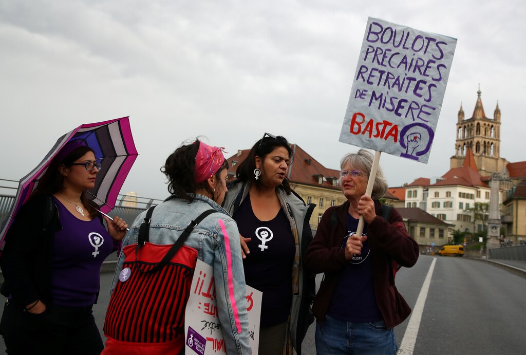 People protest on a bridge during a day-long and nationwide women's strike aimed at highlighting the country's poor record on defending the rights of women and families in Lausanne, Switzerland, June 14, 2019. The banner reads "Insecure jobs, poverty pensions, that's enough". REUTERS/Denis Balibouse - RC1F8470D9D0