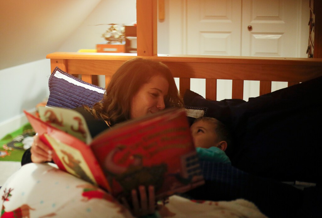 Leigh Tuttle reads a Christmas book to her son Weston Tuttle, 5, as she gets him ready for bed at their rental home in Steilacoom, Washington, U.S. November 28, 2018. Picture taken November 28, 2018. To match Special Report USA-MILITARY/DEVELOPER REUTERS/Lindsey Wasson - RC1DBB6061E0