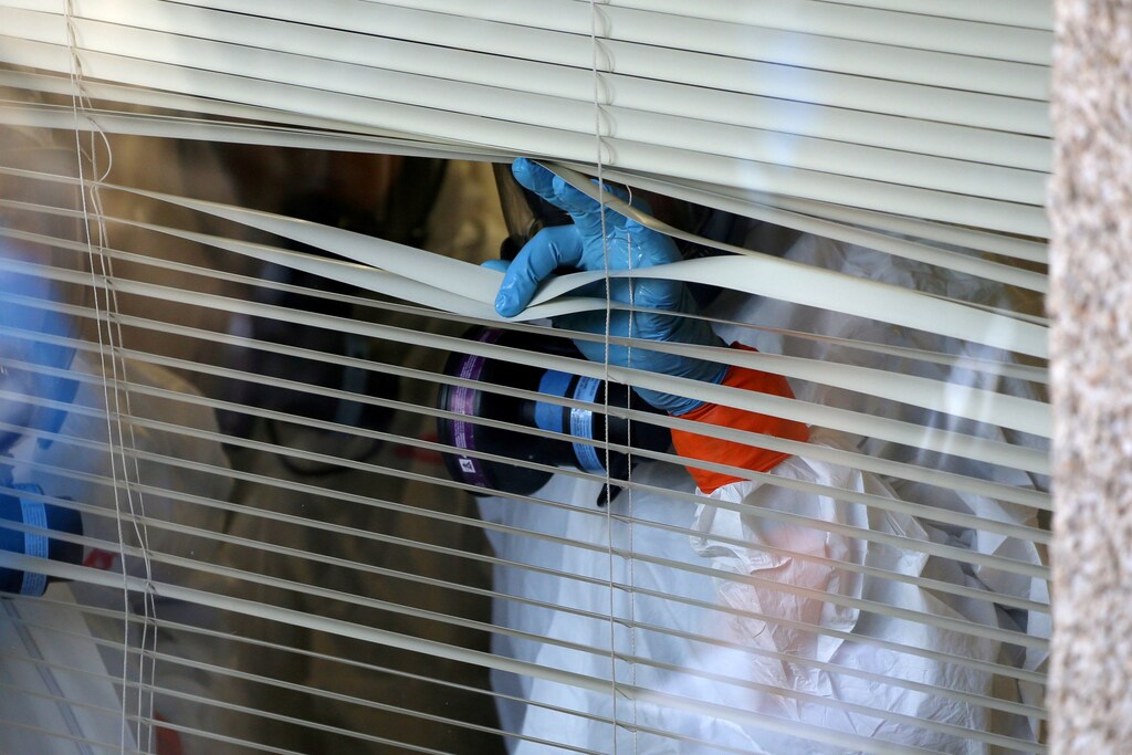 A person peers through the blinds from inside the Life Care Center of Kirkland, the long-term care facility linked to several confirmed coronavirus cases in the state, in Kirkland, Washington, U.S. March 11, 2020. REUTERS/Karen Ducey