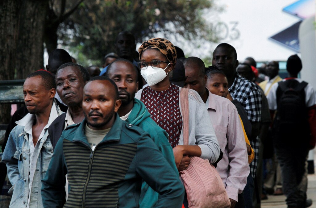Civilians queue for public transport before a curfew which was ordered by the Kenya's President Uhuru Kenyatta to contain the spread of the coronavirus disease (COVID-19), in downtown Nairobi, Kenya March 27, 2020. REUTERS/Njeri Mwangi - RC2HSF96T84M