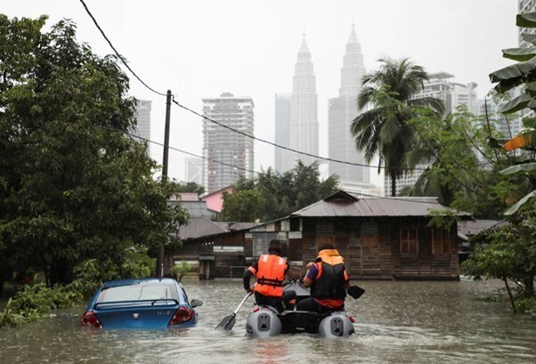 Rescue workers ride a boat through a flooded residential area in Kuala Lumpur, Malaysia.