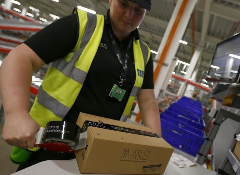 A worker boxes goods at the new Marks & Spencer e-commerce distribution centre in Castle Donington, central England May 8, 2013. The company was updating on its supply chain and IT investment programme, on Wednesday, to the media and to investors.