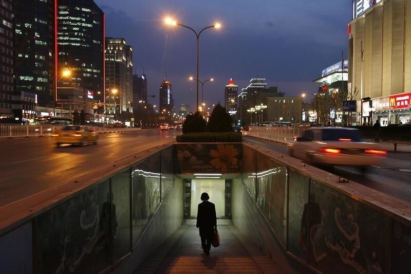 A woman walks into a subway in the central business district of Beijing April 16, 2007. China's economy probably gathered pace in the first quarter, partly on the back of resurgent loan growth and underscoring the need for Beijing to take further tightening steps in the months ahead. The median forecast of 12 economists polled by Reuters was for gross domestic product to have grown by 11.0 percent from a year earlier in the January-March period. REUTERS/Claro Cortes IV (CHINA) - GM1DVBBARIAA