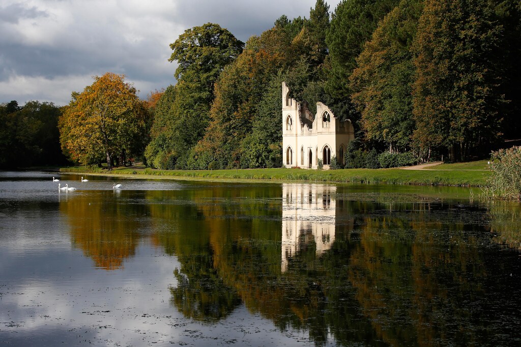 Swans swim on a lake by a folly, at Painshill 18th century landscape garden in Cobham, Britain, October 14, 2015. REUTERS/Peter Nicholls TPX IMAGES OF THE DAY - LR2EBAE11FGLE