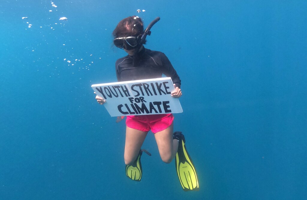 Mauritian scientist and climate change activist Shaama Sandooyea 24, holds a placard reading Youth Strike For Climate, during an underwater protest at the Saya de Malha Bank to highlight the need to protect the world's largest seagrass meadow within the Mascarene plateau, Mauritius March 6, 2021. Picture taken March 6, 2021.