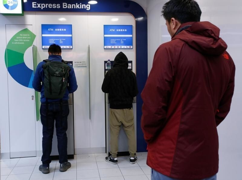 People use ATM machines at a bank in Hong Kong, China January 29, 2018. Picture taken January 29, 2018.