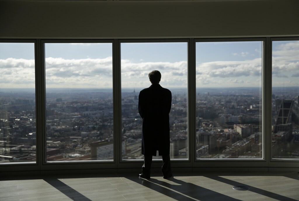 A man looks out from a window of the Torre Espacio (Space Tower) skyscraper at the northern area of Madrid, Spain, February 25, 2016. REUTERS/Andrea Comas - RTS94HO