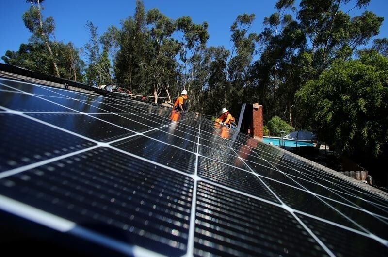 Solar installers from Baker Electric place solar panels on the roof of a residential home in Scripps Ranch, San Diego, California, U.S. October 14, 2016. Picture taken October 14, 2016. REUTERS/Mike Blake - S1AEUJDNMAAC
