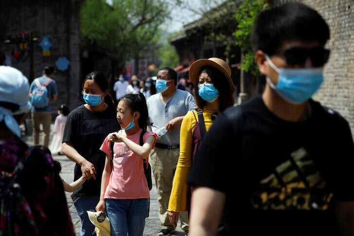 People wearing face masks visit Gubei Water Town on the first day of the five-day Labour Day holiday, following the coronavirus disease (COVID-19) outbreak, on the outskirts of Beijing, China, May 1, 2020. REUTERS/Carlos Garcia Rawlins