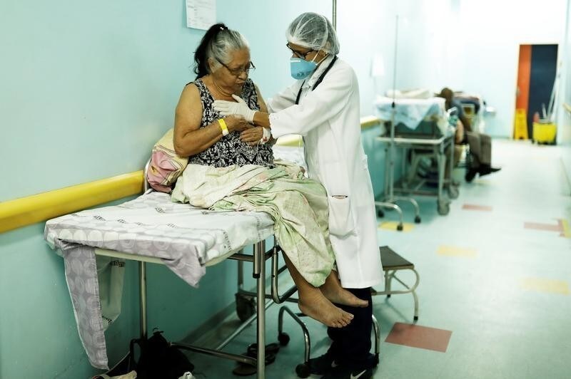 A doctor monitors a Brazilian woman as she sits on a moveable bed in the hallway of a public hospital in Boa Vista, Roraima state, Brazil August 22, 2018.