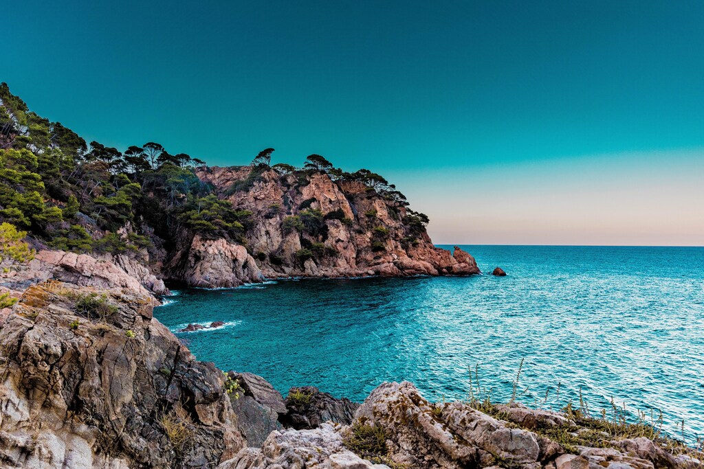Island coastline, with blue sky and sea.