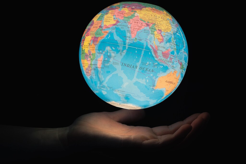 The climate crisis is at our doorstep. Pictured: Hand under a globe