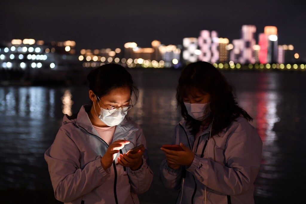 Medical workers from outside Wuhan check their mobile phones at a riverside park by the Yangtze River in Wuhan of Hubei province, the epicentre of China's coronavirus disease (COVID-19) outbreak, March 26, 2020. REUTERS/Stringer CHINA OUT. - Coronavirus china virus health healthcare who world health organization disease deaths pandemic epidemic worries concerns Health virus contagious contagion viruses diseases disease lab laboratory doctor health dr nurse medical medicine drugs vaccines vaccinations inoculations technology testing test medicinal biotechnology biotech biology chemistry physics microscope research influenza flu cold common cold bug risk symptomes respiratory china iran italy europe asia america south america north washing hands wash hands coughs sneezes spread spreading precaution precautions health warning covid 19 cov SARS 2019ncov wuhan sarscow wuhanpneumonia pneumonia outbreak patients unhealthy fatality mortality elderly old elder age serious death deathly deadly