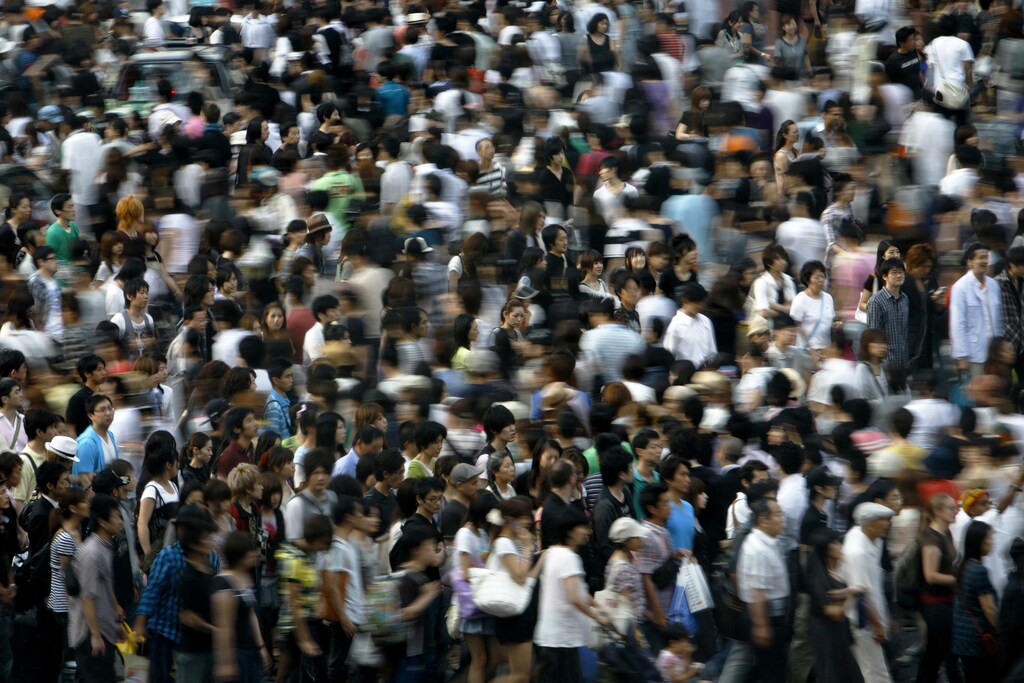 People walk across a street in Tokyo July 12, 2009. REUTERS/Stringer (JAPAN BUSINESS SOCIETY) - GM1E57L18PB01