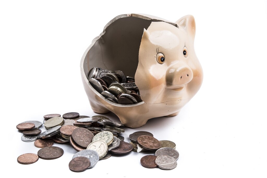 Broken piggy bank with UK currency falling out: People are embracing tokenisation and smart financial contracts.