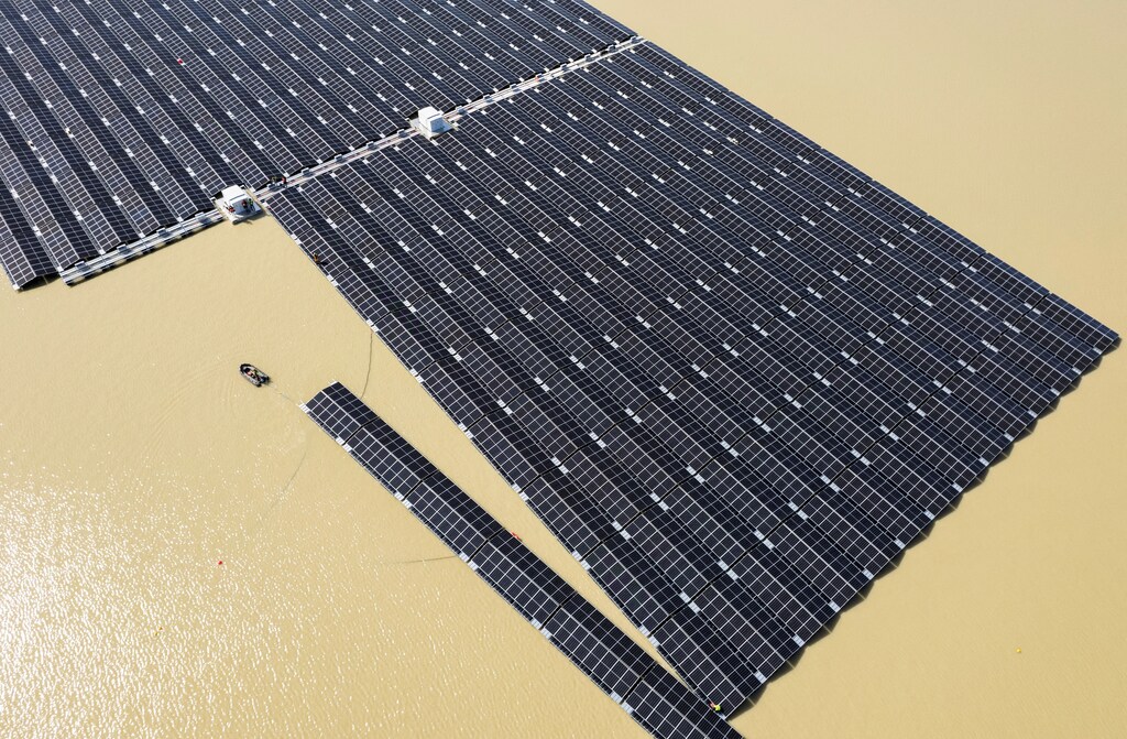 A boat pulls solar panels towards a floating photovoltaic power plant on Lake Silbersee, Germany. Phase Down Finance can assist in managing the socio-economic consequences of transition while ensuring Paris-aligned outcomes.