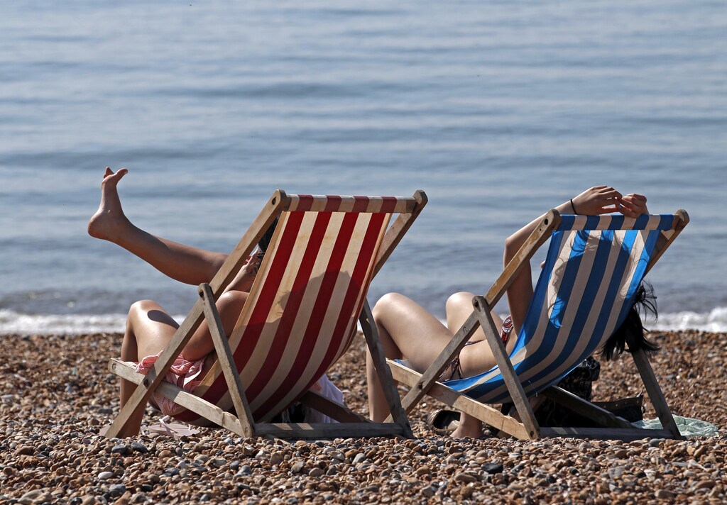 People enjoy the sunshine on the beach in Brighton, southern England April 20, 2011. REUTERS/Luke MacGregor (BRITAIN - Tags: ENVIRONMENT SOCIETY) - GM1E74K1PVY01