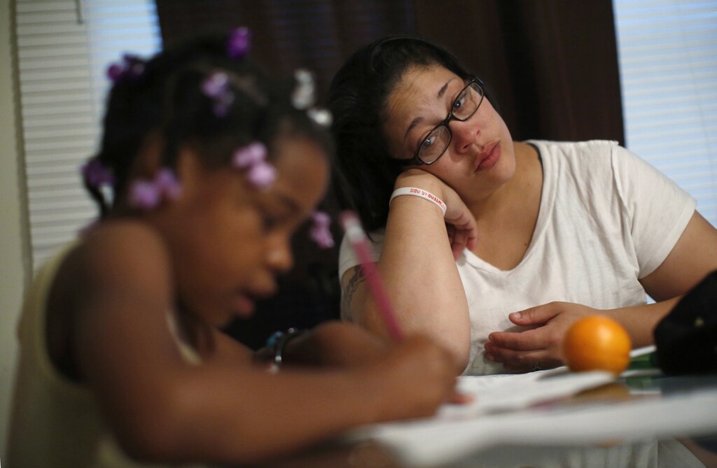 Delores Leonard (R) helps her daughter Erin with her homework at the breakfast table before heading to work at a McDonald's Restaurant in Chicago, Illinois, September 25, 2014. Leonard, a single mother raising two daughters, has been working at McDonald's for seven years and has never made more than minimum wage. Picture taken September 25, 2014. REUTERS/Jim Young (UNITED STATES - Tags: BUSINESS EMPLOYMENT TPX IMAGES OF THE DAY) - GM1EAAH1LAM01