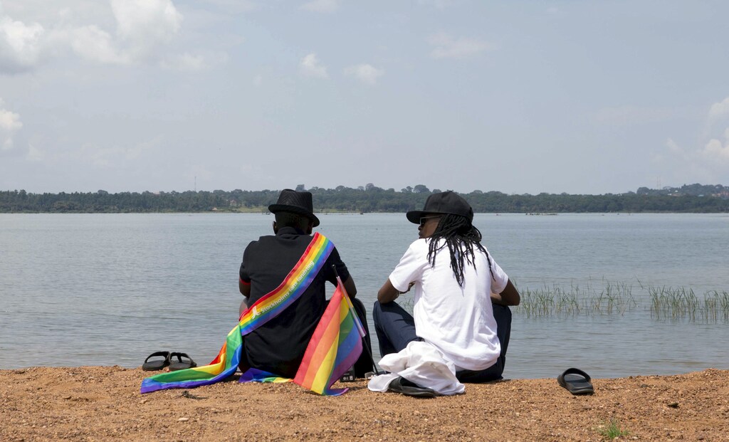A gay couple chats by a beach before a parade by members of the lesbian, gay, bisexual and transgender (LGBT) community in Entebbe, southwest of Uganda's capital Kampala, August 8, 2015