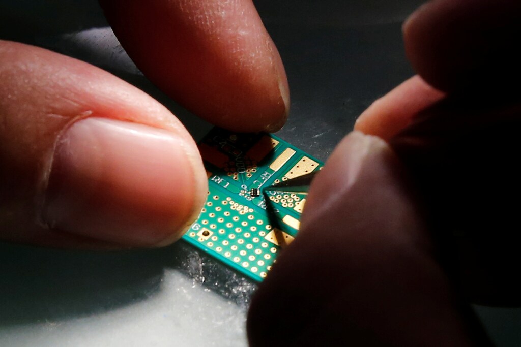 A researcher plants a semiconductor on an interface board.