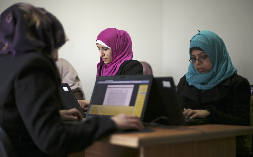 Palestinian employees process data on their laptops at Unit One in Gaza City January 15, 2015. In nine years, Gaza-based IT entrepreneur Saady Lozon and his partner Ahmed Abu Shaban have transformed their firm, Unit One, from a tiny outfit in a single room in the blockaded Gaza Strip into a successful business with clients in Europe, the United States and the Arab world. They can't leave Gaza easily, but they can develop applications for Web and mobile devices online and provide international clients with data-management services, competing with firms in India and elsewhere.