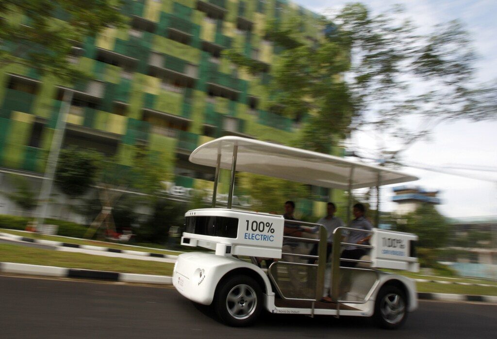 People ride on a driverless electric vehicle at the Nanyang Technological University (NTU) in Singapore September 4, 2013. The eight-passenger shuttle vehicle named Navia makes use of laser rangefinders, cameras and a navigation software that allows it to move autonomously and safely at speeds up to 20 km/h, according to manufacturer Induct. Induct and NTU's Energy Research Institute has teamed up to test and optimize Navia in a two-year collaboration aimed at improving the reliability of the battery and reducing charging time, according to local media. REUTERS/Edgar Su (SINGAPORE - Tags: TRANSPORT SCIENCE TECHNOLOGY SOCIETY ENERGY EDUCATION) - GM1E9941K2Y01