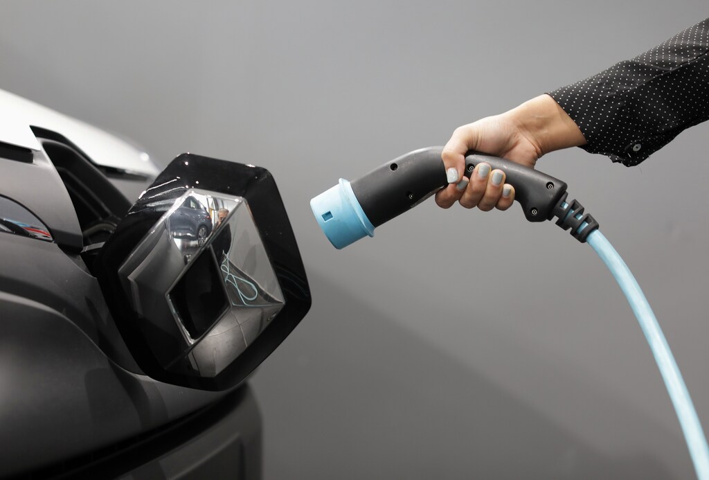A woman holds a cable to charge up a Renault Kangoo ZE electric utility vehicle at a Renault automobile dealership in Cagnes-Sur-Mer, France, October 22, 2020. Picture taken October 22, 2020. REUTERS/Eric Gaillard - RC2UUJ9H9VY9