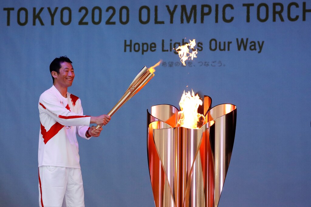 Olympic torch bearer Yoshihide Muroya, Japanese aerobatics pilot and race pilot of the Red Bull Air Race World Championship, lights the celebration cauldron at Hibarigahara Festival Site, during the last leg of the first day of the Tokyo 2020 Olympic torch relay, in Minamisoma, Fukushima prefecture, Japan, March 25, 2021.