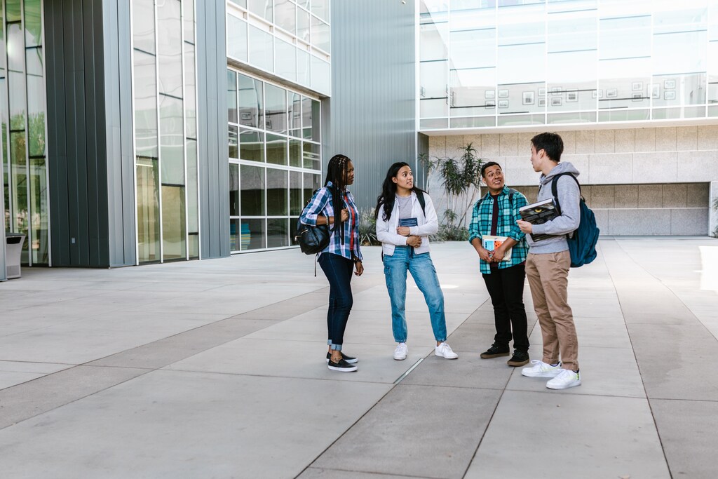 University students holding books and talking