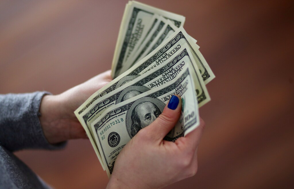 A woman counts U.S. dollar bills at her home in Buenos Aires, Argentina August 28, 2018. REUTERS/Marcos Brindicci - RC1F1F4E9690