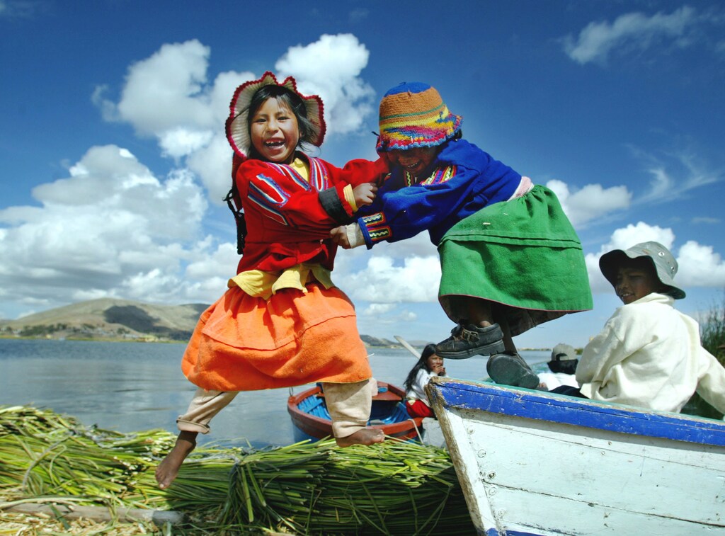 PICTURES OF THE YEAR 2004 Uro children play on a boat on Uro island in Lake Titicaca, November 5, 2004. The Floating Islands of Uros are made by natives from compacted beds of totora reeds. The islands are located in Lake Titicaca, the worlds highest navigable lake at over 4,000 meters above sea level. The Uros people fish and hunt, but tourism is the main source of livelihood. PHOTO TAKEN NOVEMBER 5. REUTERS/Pilar Olivares - RTRIEKO