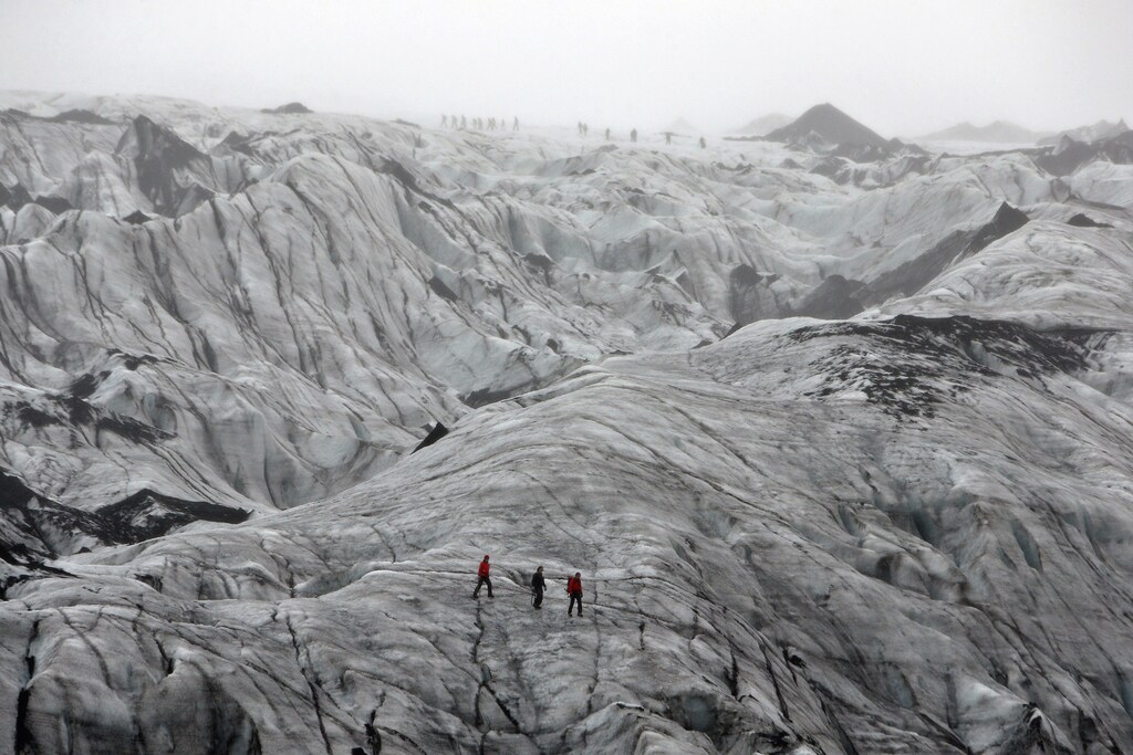 A view shows tourists walking on the Solheimajokull Glacier, where the ice has receded by more than 1 kilometer (0.6 miles) since annual measurements began in 1931, Iceland October 16, 2015. The French President went to the glacier to experience firsthand the damage caused by global warming, ahead of major U.N. talks on climate change in Paris this year. France is host to the World Climate Change Conference 2015 (COP21) from November 30 to December 11. Picture taken October 16, 2015. REUTERS/Thibault Camus/Pool - PM1EBAI1IQ201