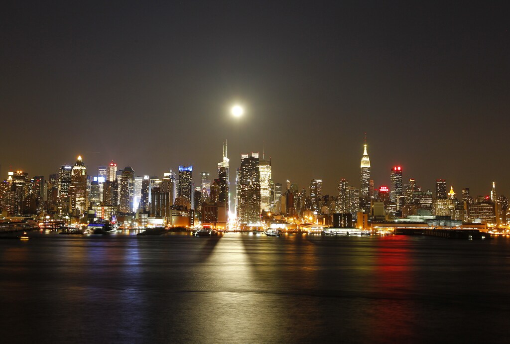 A full moon rises over the New York skyline above 42nd Street (C), seen from across the Hudson River in Weehawken in this New Jersey April 25, 2013 file photo. New York City is iconic in any weather, but the warm season adds a special flavour to its bustling streets, leafy parks and world-famous skyline. The summer is about to draw to a close, as fall begins in the northern hemisphere with the Autumnal Equinox on September 22. Picture taken April 25, 2013. REUTERS/Gary Hershorn/Files (UNITED STATES - Tags: CITYSCAPE SOCIETY) ATTENTION EDITORS: PICTURE 04 OF 40 FOR PACKAGE 'NYC - A SEASON IN THE CITY' SEARCH 'NYC HERSHORN' FOR ALL IMAGES - RTX13TBE