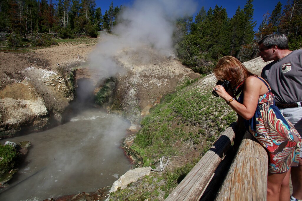 Tourist photograph the Dragon's Mouth Spring in the Mud Volcano in Yellowstone National Park, Wyoming, June 23, 2011. REUTERS/Jim Urquhart (UNITED STATES) - LM2E76S1FE601