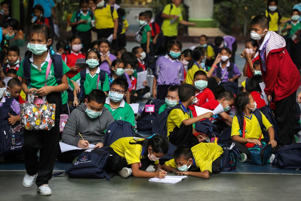Students wear masks as they wait to be picked up, as classes in over 400 Bangkok schools have been cancelled due to worsening air pollution, at a public school in Bangkok, Thailand, January 30, 2019.