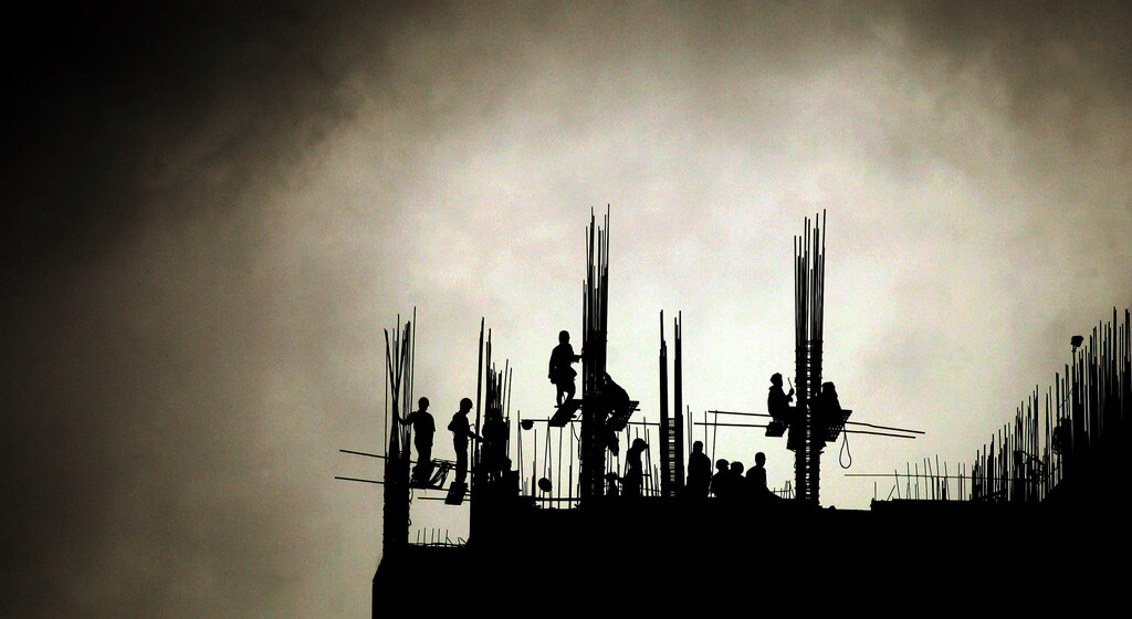 Indian workers engage in the construction of a high-rise building on a cloudy day in Bombay June 29, 2005. India's southwest monsoon has spread to about three-quarters of the country, including the capital New Delhi, which has led to increased sowing of winter crops, weather officials and traders said on Monday. REUTERS/Arko Datta AD/KS - RP6DRMTULNAA