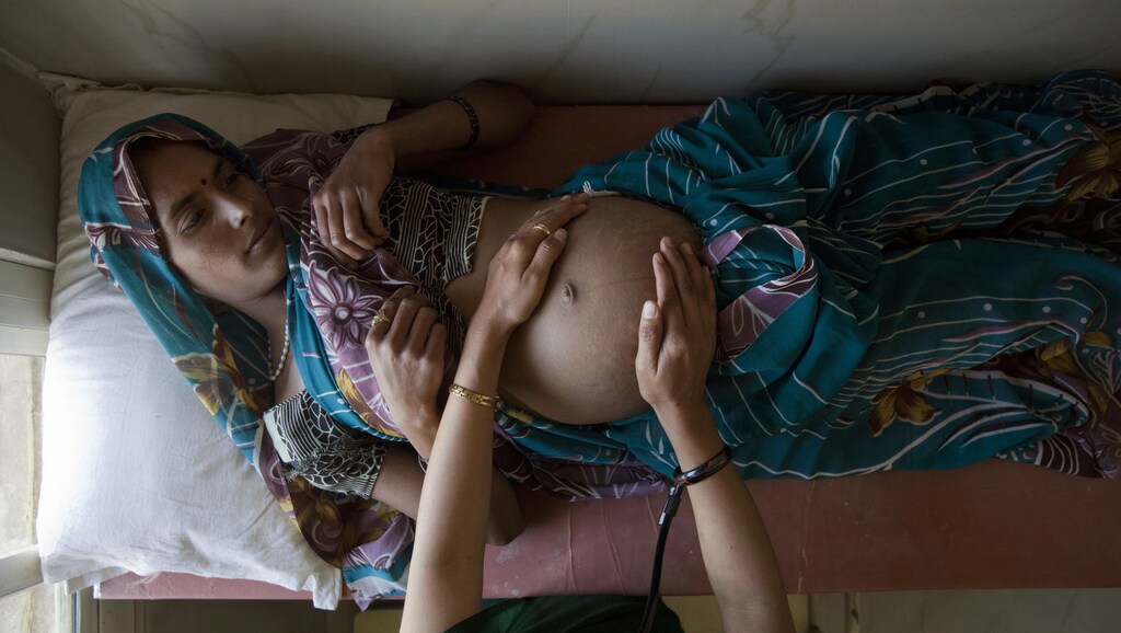 Suman, a 25-year-old pregnant woman, lies on an examination table as a nurse places her hands on her stomach during a check up at a community health centre in the remote village of Chharchh, in the central Indian state of Madhya Pradesh, February 24, 2012.
