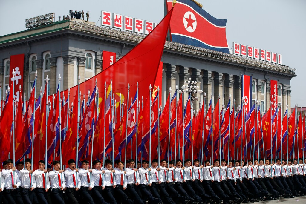 Men carry flags in front of the stand with North Korean leader Kim Jong Un and other high ranking officials during a military parade marking the 105th birth anniversary of the country's founding father, Kim Il Sung, in Pyongyang April 15, 2017. REUTERS/Damir Sagolj - RC1E0D7F7270