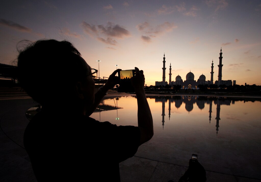A visitor takes photos of Sheikh Zayed Mosque with their smart phone in Abu Dhabi, United Arab Emirates, December 25, 2018. Picture taken December 25, 2018. REUTERS/ Hamad I Mohammed - RC17408E37F0