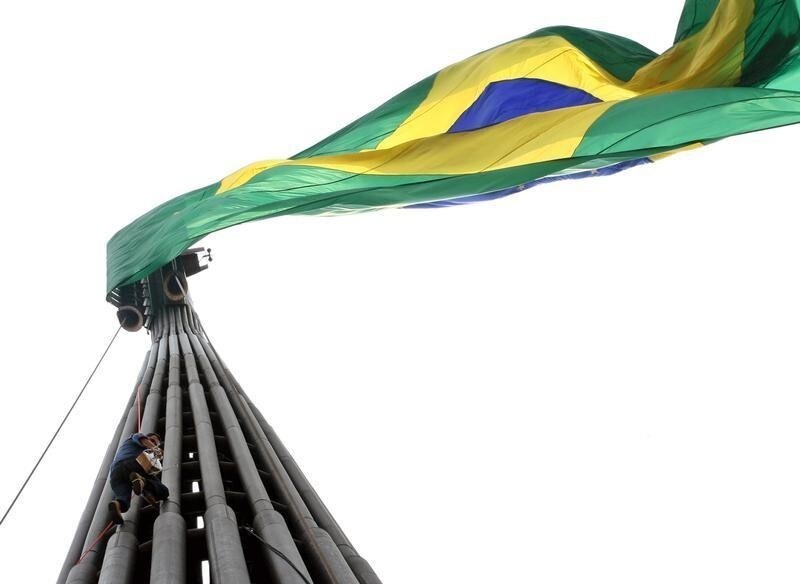 Brazilian farmer Vicente Rodrigues climbs almost half way up the 110-meter high flagpole located in Tres Poderes square in protest against what he says are the high unemployment, insecurity, corruption and tax rates in the country, in Brasilia September 21, 2006. Rodrigues remained tied to the flagpole for three hours before firemen removed him.